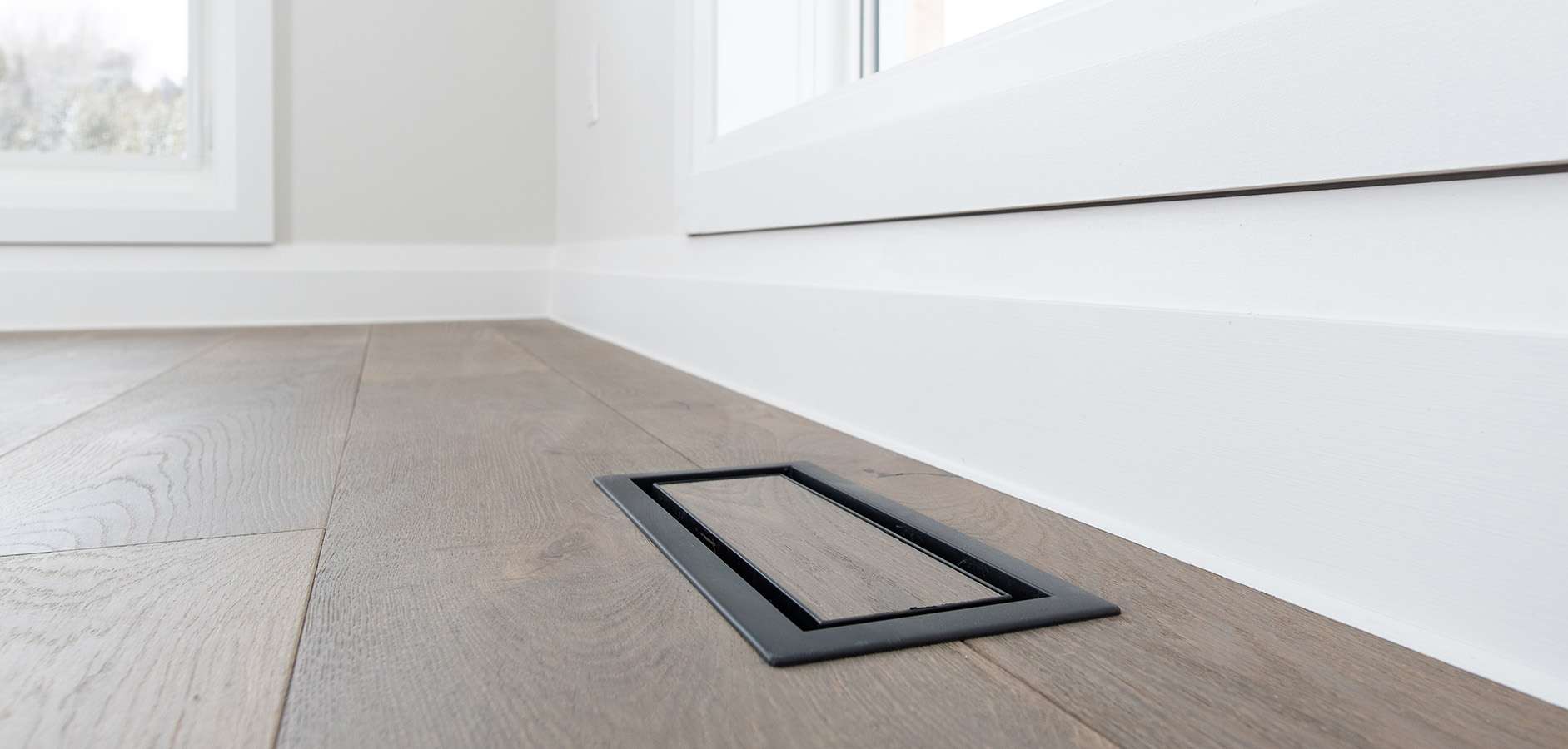 Flush wood floor vent detail in wide plank oak flooring by Revel Homes