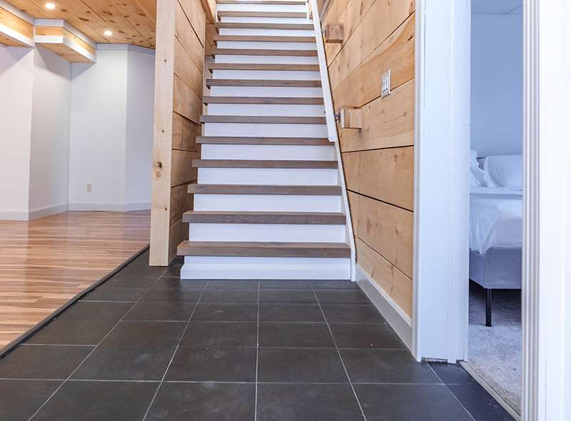 Finished basement stairs with pine feature walls and slate tile by Revel Homes, Meaford Ontario