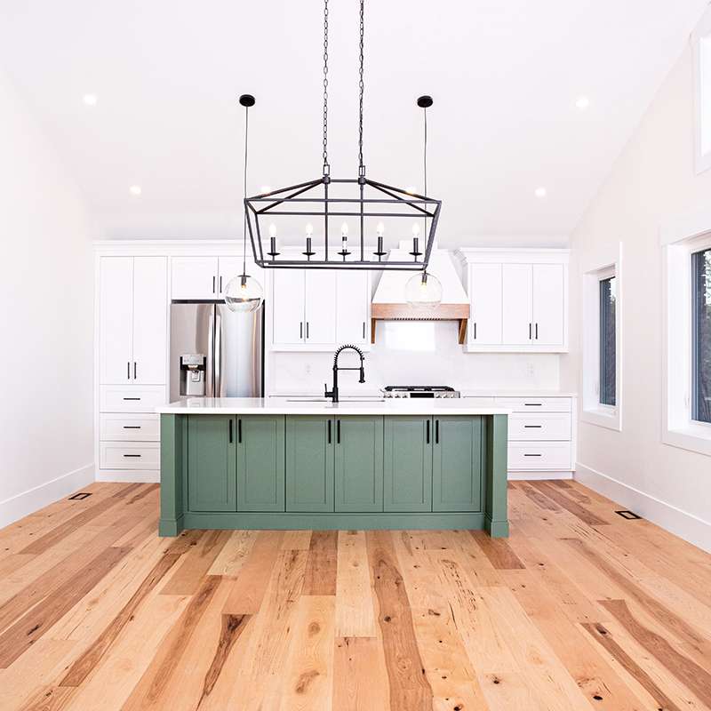 Custom kitchen with green island built on budget by Revel Homes in Wasaga Beach, Ontario