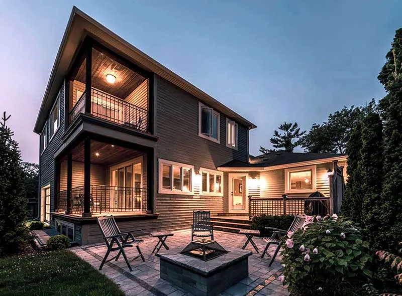 Rear patio and outdoor living space of a Mulmur custom home by Revel Homes at dusk