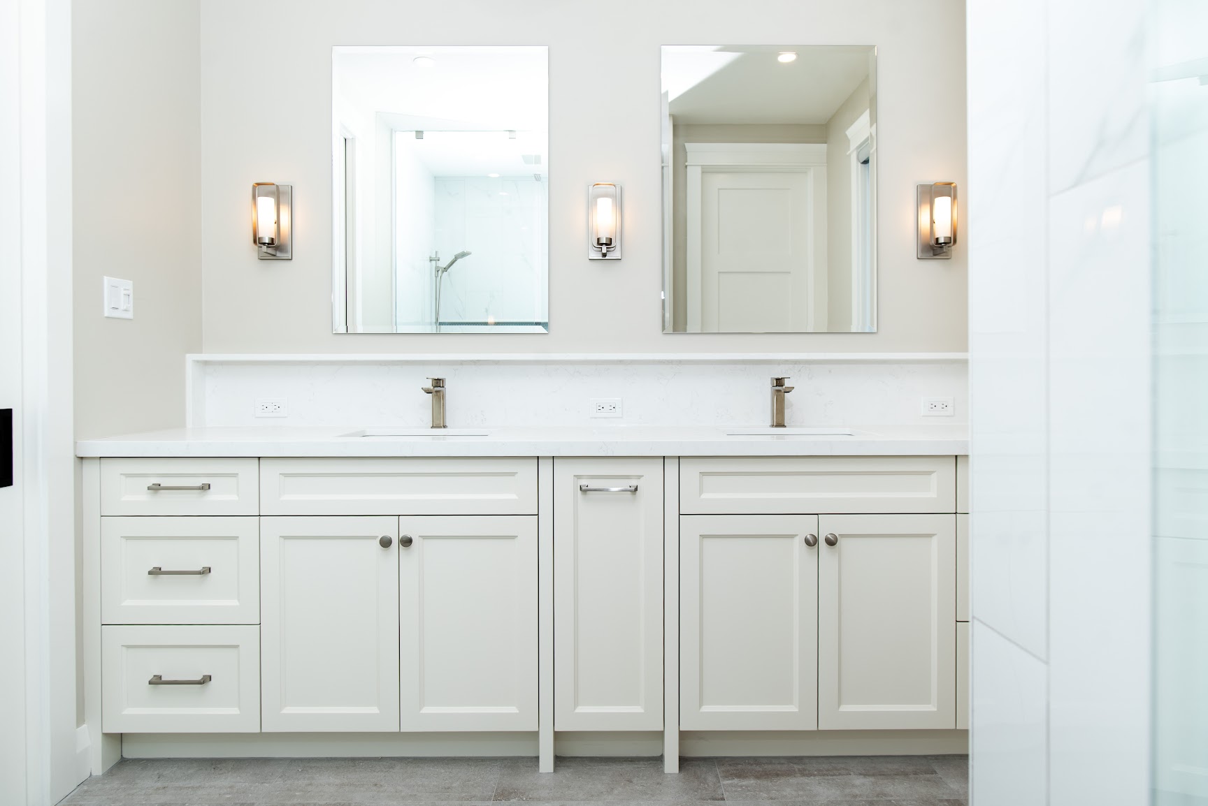Double vanity bathroom with quartz counters and sconce lighting in a custom home by Revel Homes, Meaford area home builder
