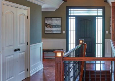 Front entry and foyer with wainscoting and custom millwork by Revel Homes
