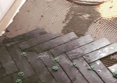 Herringbone tile floor installation by Revel Homes